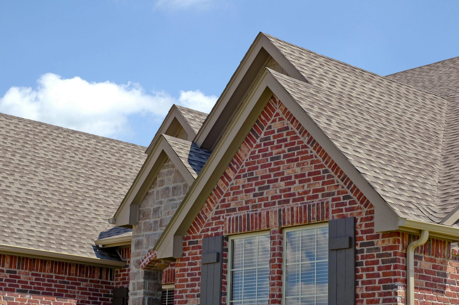 Traditional brick home with layered shingle roof