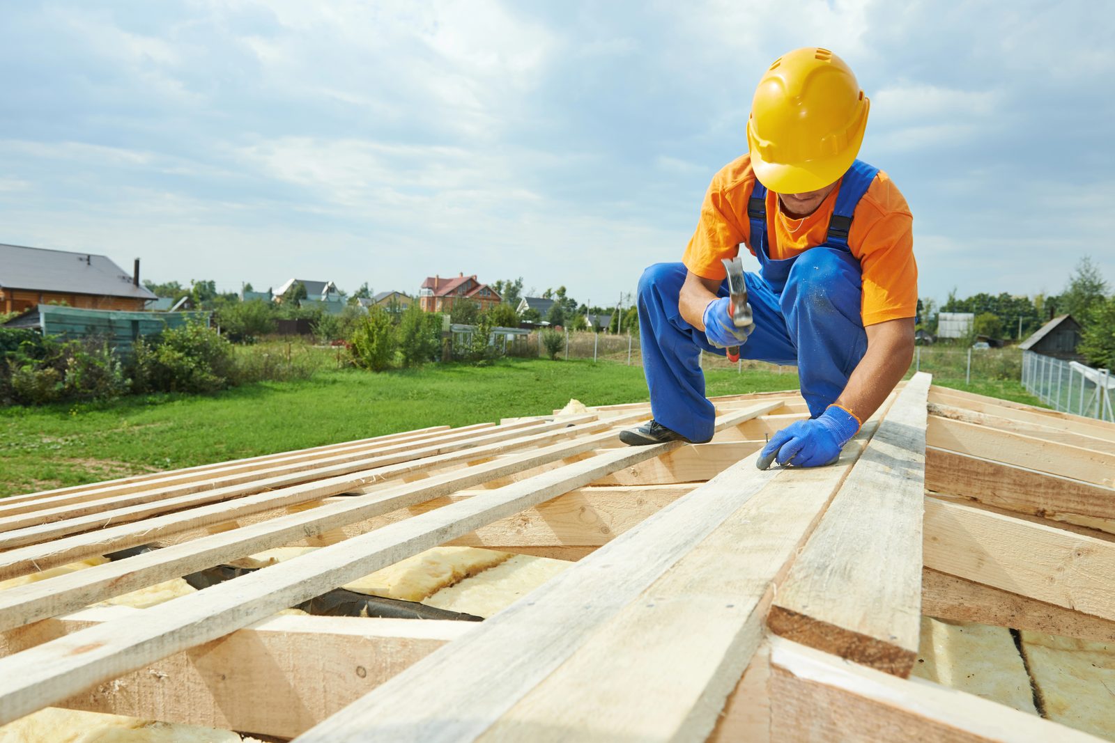 Worker building roof frame during new construction