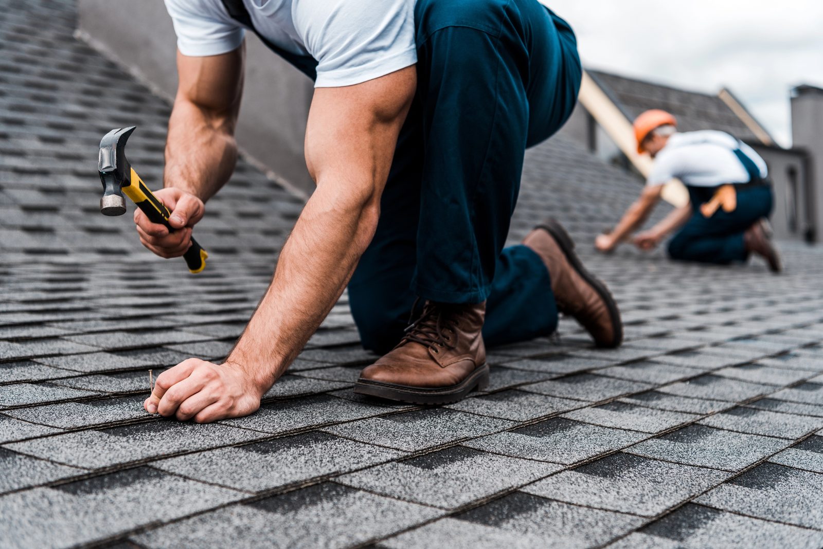 Professional roofer at work on residential roof