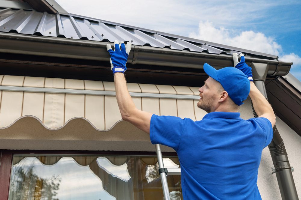 Worker inspecting metal standing seam roof